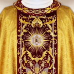 Chasuble brodée dorée avec une bande bordeaux et broderie IHS