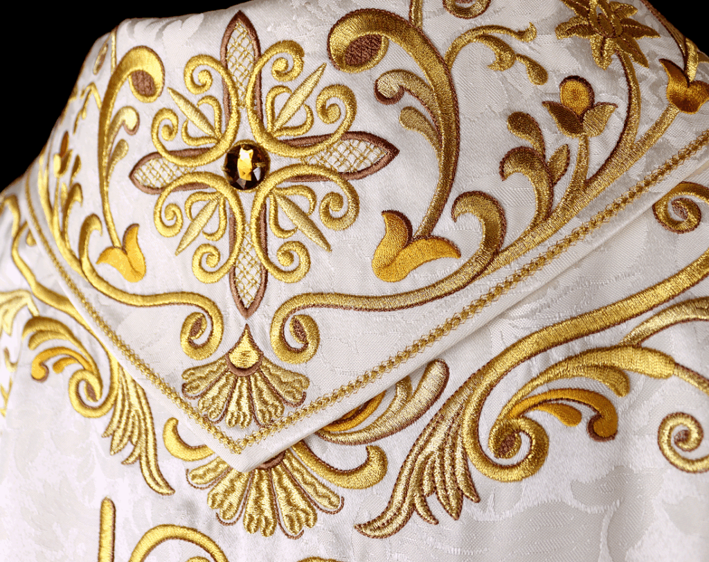 Gros plan sur la broderie liturgique dorée de l'aube « Jésus Miséricordieux » – détail de la réalisation