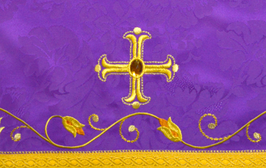 Une croix brodée au fil d'or sur une chasuble liturgique