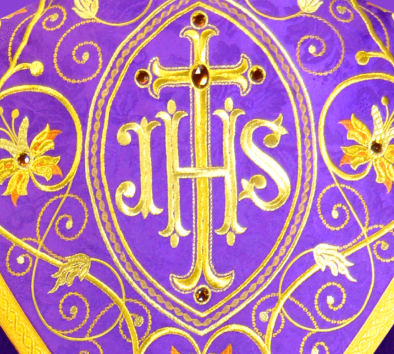 détail de la broderie liturgique IHS sur l'aube – ornement eucharistique