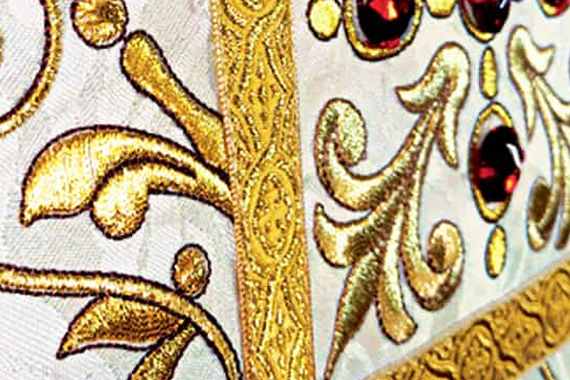 Broderie sacrée dorée sur une chasuble liturgique blanche